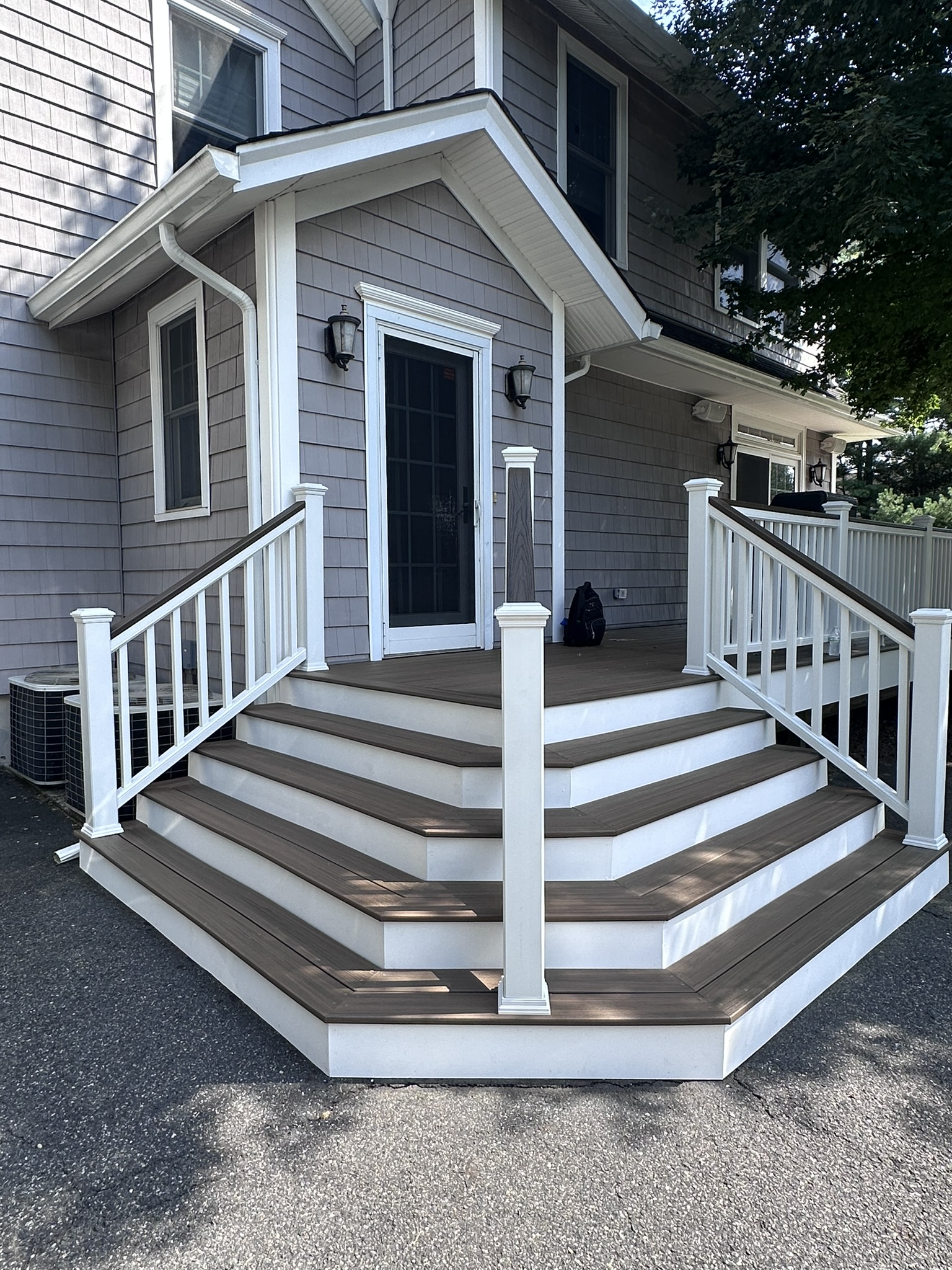 Custom cascading composite entry stairs in Glen Rock, NJ with dark Trex treads and white railings