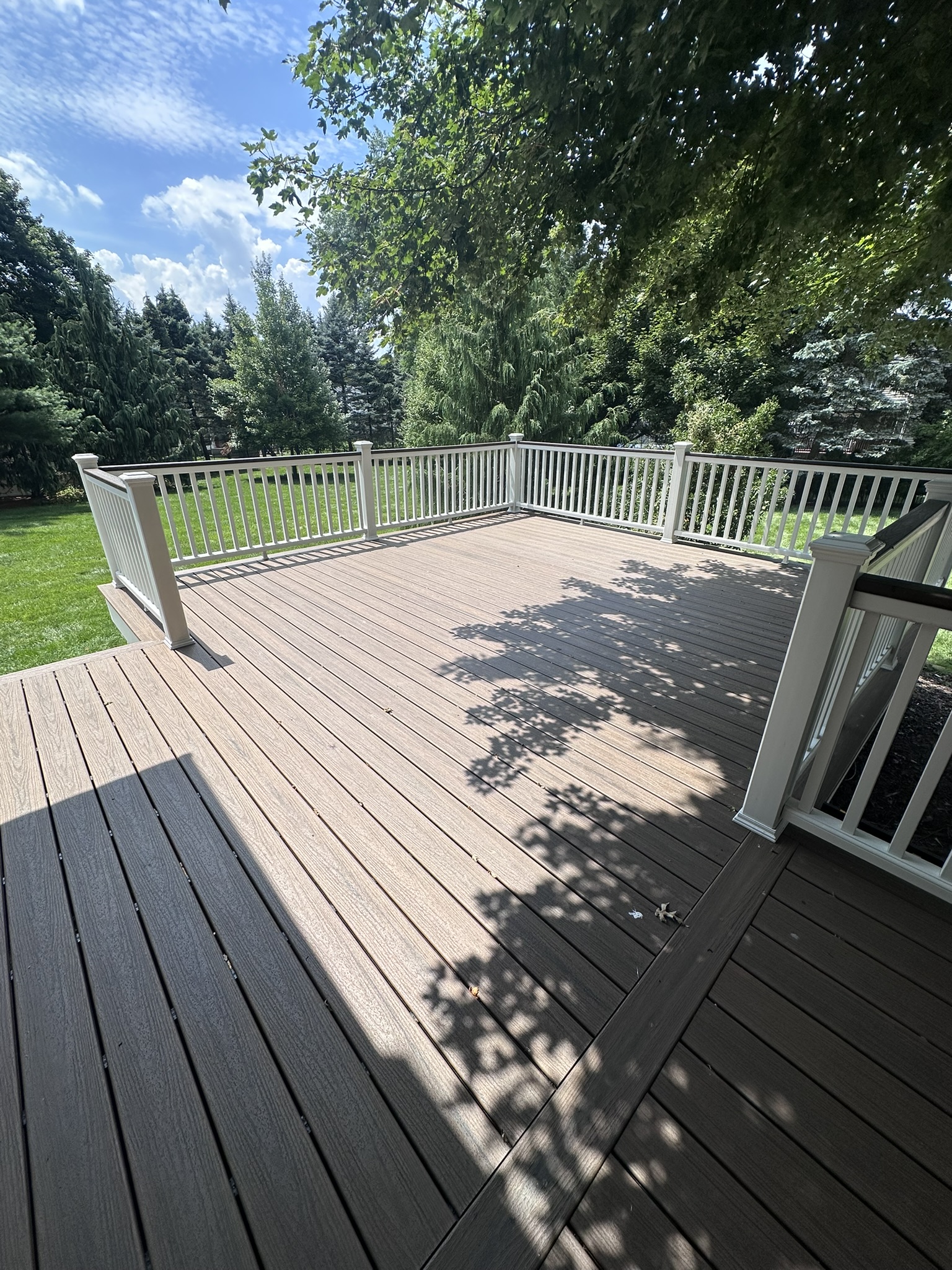 Finished composite deck in Glen Rock NJ with white Trex Transcend railing overlooking the lawn