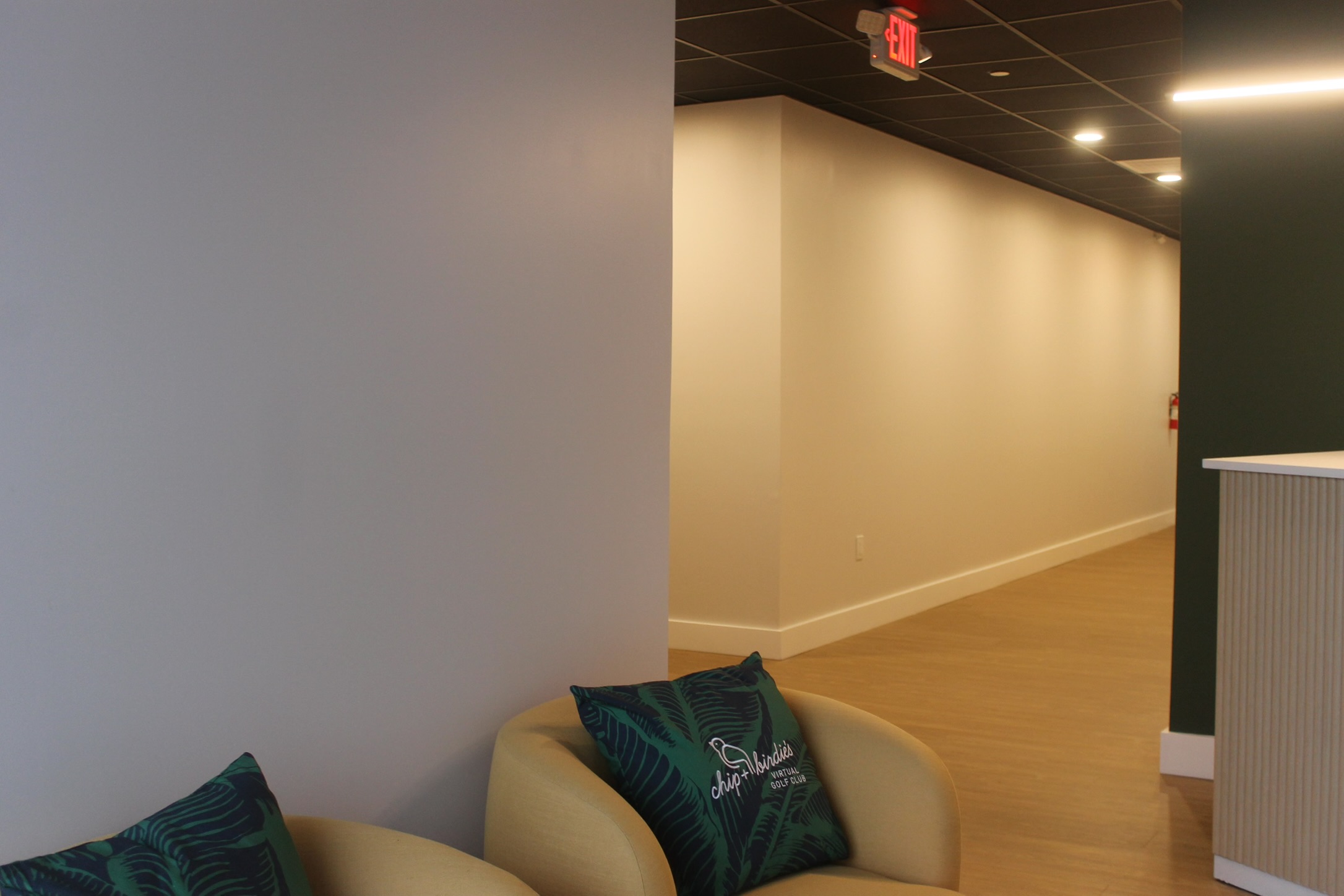 Corridor at Chip & Birdie&rsquo;s in Mountainside NJ showing the black tile ceiling set at 12 feet above recessed lighting
