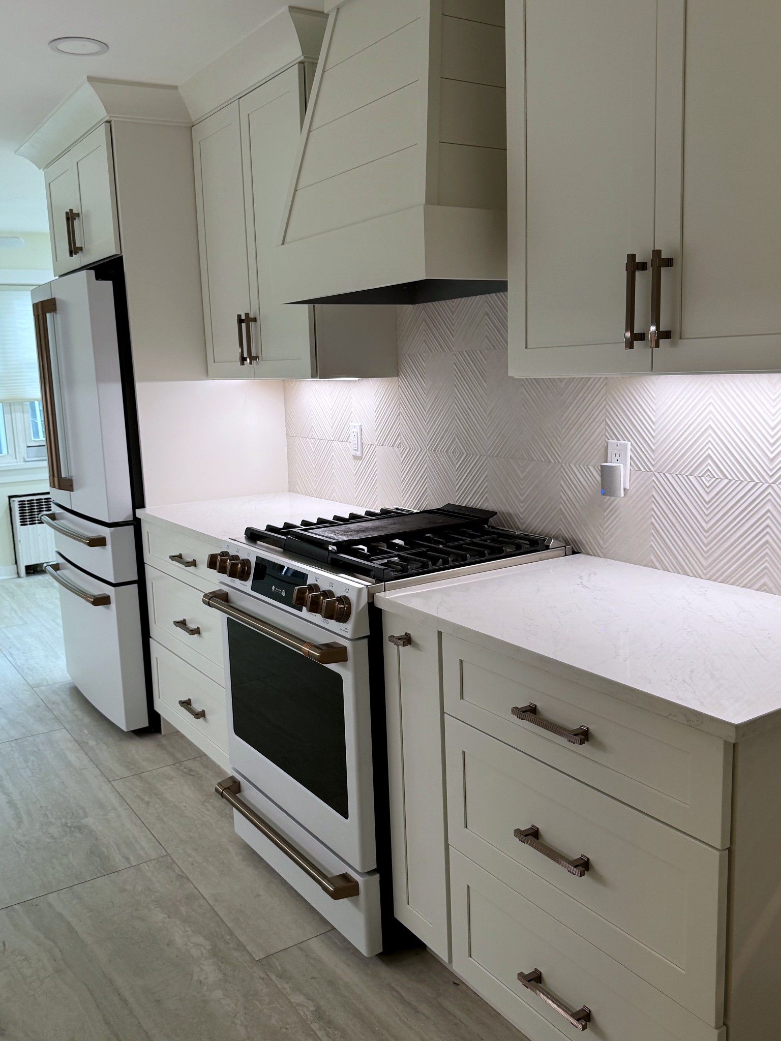Range wall of the Montclair kitchen with custom panelled hood surround and textured tile
